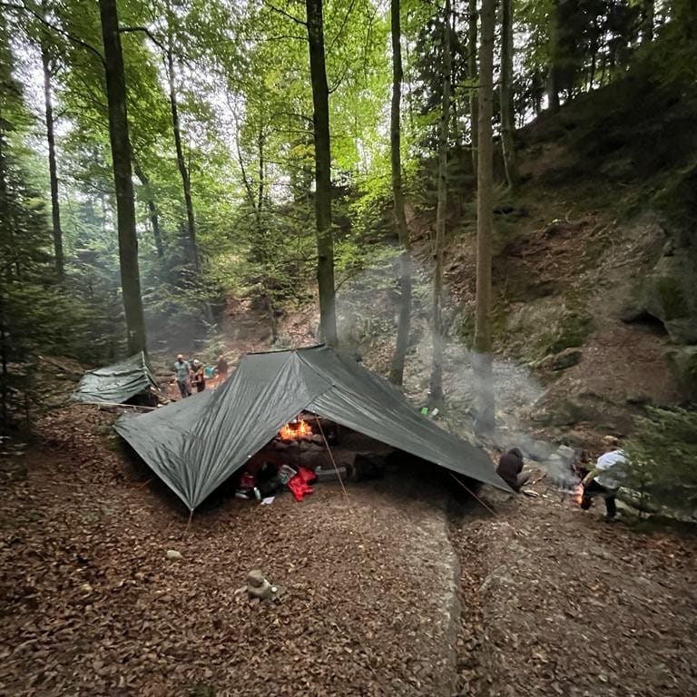 Waldspielgruppe macht ein Lagerfeuer und erkundet die Natur